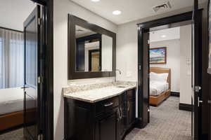 Ensuite bathroom with visible vents, ensuite bathroom, recessed lighting, baseboards, and vanity