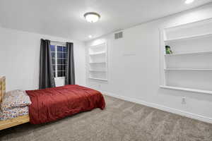 Carpeted bedroom with recessed lighting, visible vents, and baseboards