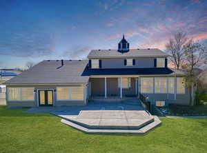 Rear view of property with a yard, a patio, and french doors