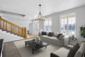 Living room featuring light carpet, recessed lighting, stairway, an inviting chandelier, and baseboards