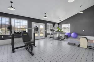 Exercise room featuring tile patterned floors, french doors, and high vaulted ceiling