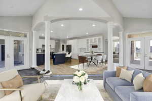 Living area featuring recessed lighting, french doors, arched walkways, decorative columns, and vaulted ceiling