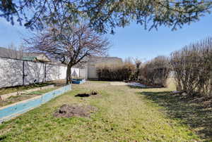 View of yard with a garden and fence