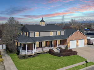 Country-style home with a lawn, driveway, a porch, a residential view, and a garage