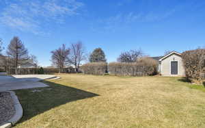 View of yard featuring an outbuilding, a patio area, and fence