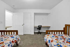 Bedroom featuring carpet flooring, baseboards, and built in desk