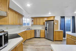 Kitchen featuring a sink, recessed lighting, stainless steel appliances, light wood-style floors, and light countertops