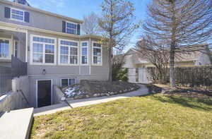 Back of property featuring a lawn and fence