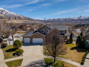 Traditional home with a mountain view, driveway, an attached garage, and fence