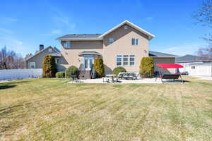 Rear view of property featuring a patio, entry steps, a lawn, and fence