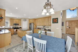 Dining area with light tile patterned floors, recessed lighting, and a chandelier