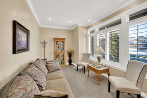 Living area featuring recessed lighting, baseboards, carpet, and crown molding