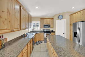 Kitchen with light brown cabinets, stainless steel appliances, and a sink