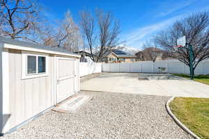 View of yard with a patio area, a shed, an outbuilding, and a fenced backyard