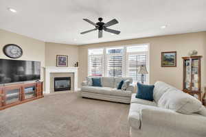 Living area featuring recessed lighting, carpet floors, a ceiling fan, and a tiled fireplace