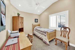 Carpeted bedroom featuring recessed lighting, a ceiling fan, baseboards, and vaulted ceiling