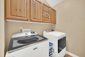 Laundry room featuring cabinet space, washing machine and dryer, and baseboards