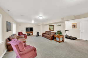 Living area featuring visible vents, baseboards, and carpet