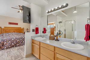 Full bathroom with double vanity, a stall shower, and a sink