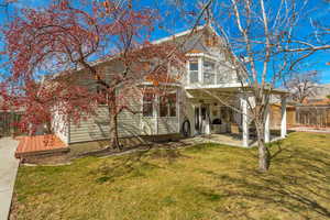 View of front of home featuring a front yard, a patio area, and fence