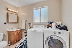 Laundry area featuring light tile patterned floors, separate washer and dryer, and laundry area
