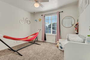 Bedroom with a ceiling fan, baseboards, and carpet floors