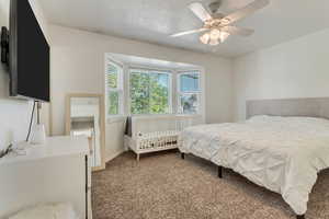 Carpeted bedroom with baseboards and ceiling fan