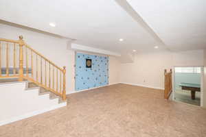 Below grade area with stairs, recessed lighting, and baseboards