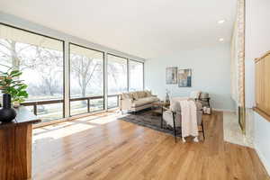 Living area with recessed lighting, baseboards, light wood-style floors, and floor to ceiling windows