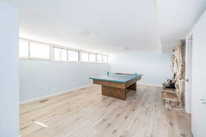 Recreation room with visible vents, baseboards, and light wood-style floors