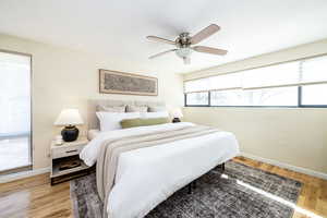 Bedroom with baseboards, light wood finished floors, and ceiling fan