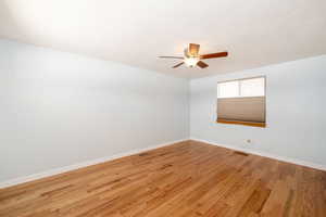 Empty room featuring a ceiling fan, visible vents, baseboards, light wood-style floors, and a textured ceiling