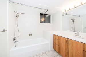 Full bathroom featuring shower / tub combination, vanity, and tile patterned flooring