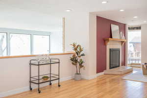 Living room featuring recessed lighting, baseboards, a tile fireplace, and hardwood / wood-style flooring