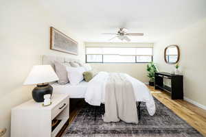 Bedroom with a ceiling fan, baseboards, and wood finished floors