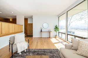 Living area featuring recessed lighting, light wood-style flooring, baseboards, and expansive windows