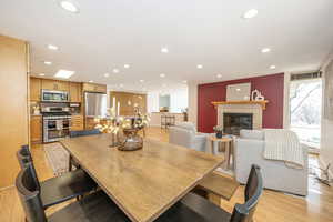 Dining space with recessed lighting, light wood-style flooring, and a tile fireplace