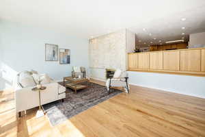 Living area with recessed lighting, a fireplace, baseboards, and wood finished floors