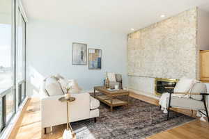 Living area with visible vents, recessed lighting, wood finished floors, and a premium fireplace