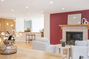 Living room with recessed lighting, baseboards, wood finished floors, and a fireplace