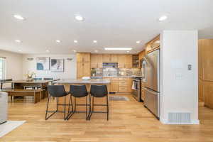 Kitchen with visible vents, light brown cabinetry, a sink, appliances with stainless steel finishes, and light countertops