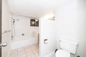 Full bath with baseboards, toilet, shower / bathtub combination, and tile patterned flooring