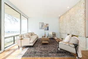 Living room with visible vents, recessed lighting, a wall of windows, and wood finished floors