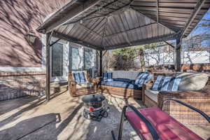 View of patio featuring an outdoor living space, a gazebo, and fence