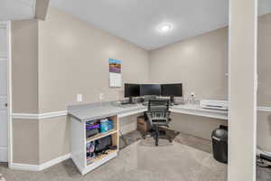 Office space with baseboards and carpet