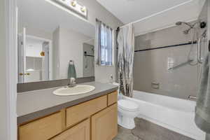 Bathroom featuring vanity, shower / tub combo, and toilet