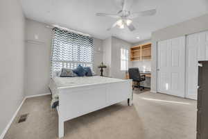 Bedroom with visible vents, baseboards, light colored carpet, and ceiling fan