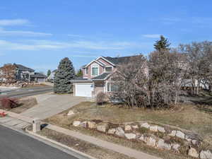 View of front of property with concrete driveway, an attached garage, fence, and brick siding