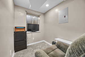 Interior space with electric panel, recessed lighting, baseboards, and carpet