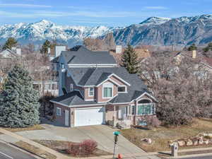 View of front of house featuring brick siding, a mountain view, a shingled roof, and driveway